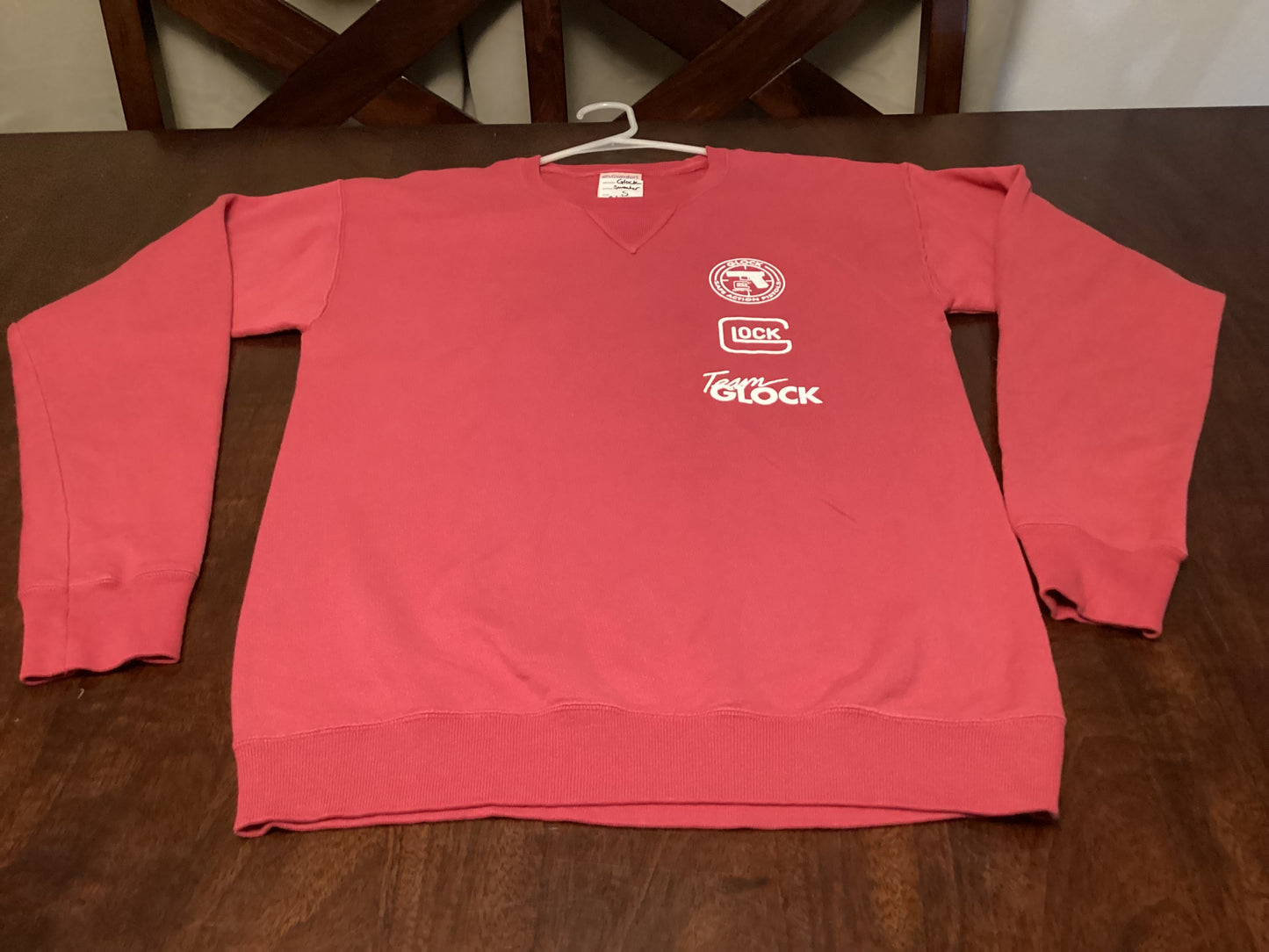 Front view of the bold red Team Glock crewneck sweatshirt, size small, with iconic Safe Action Heat branding, crafted for fans and fashion lovers at ShAesthetics