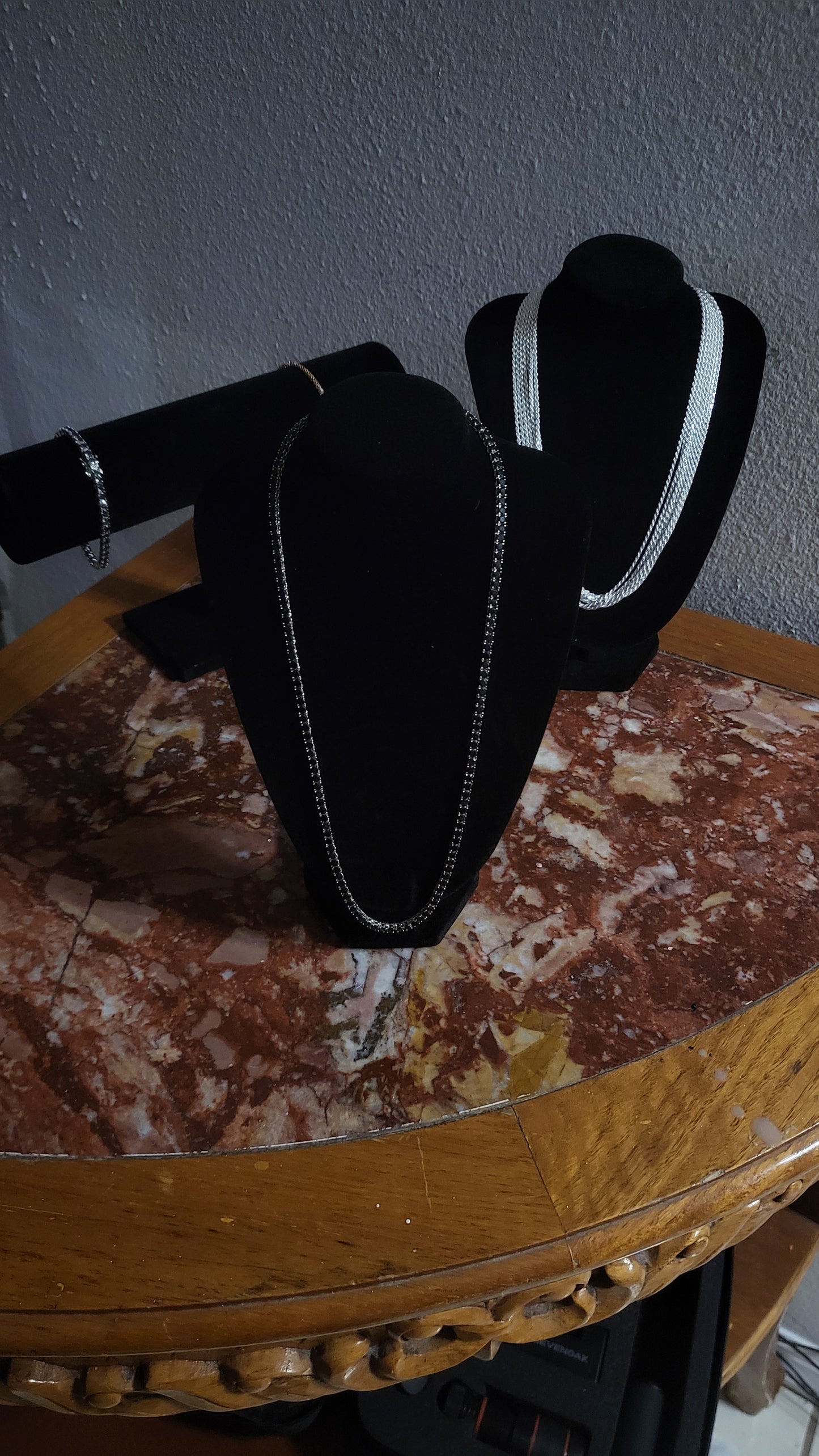 Close-up of black onyx stones in sterling silver tennis setting, shining under direct light