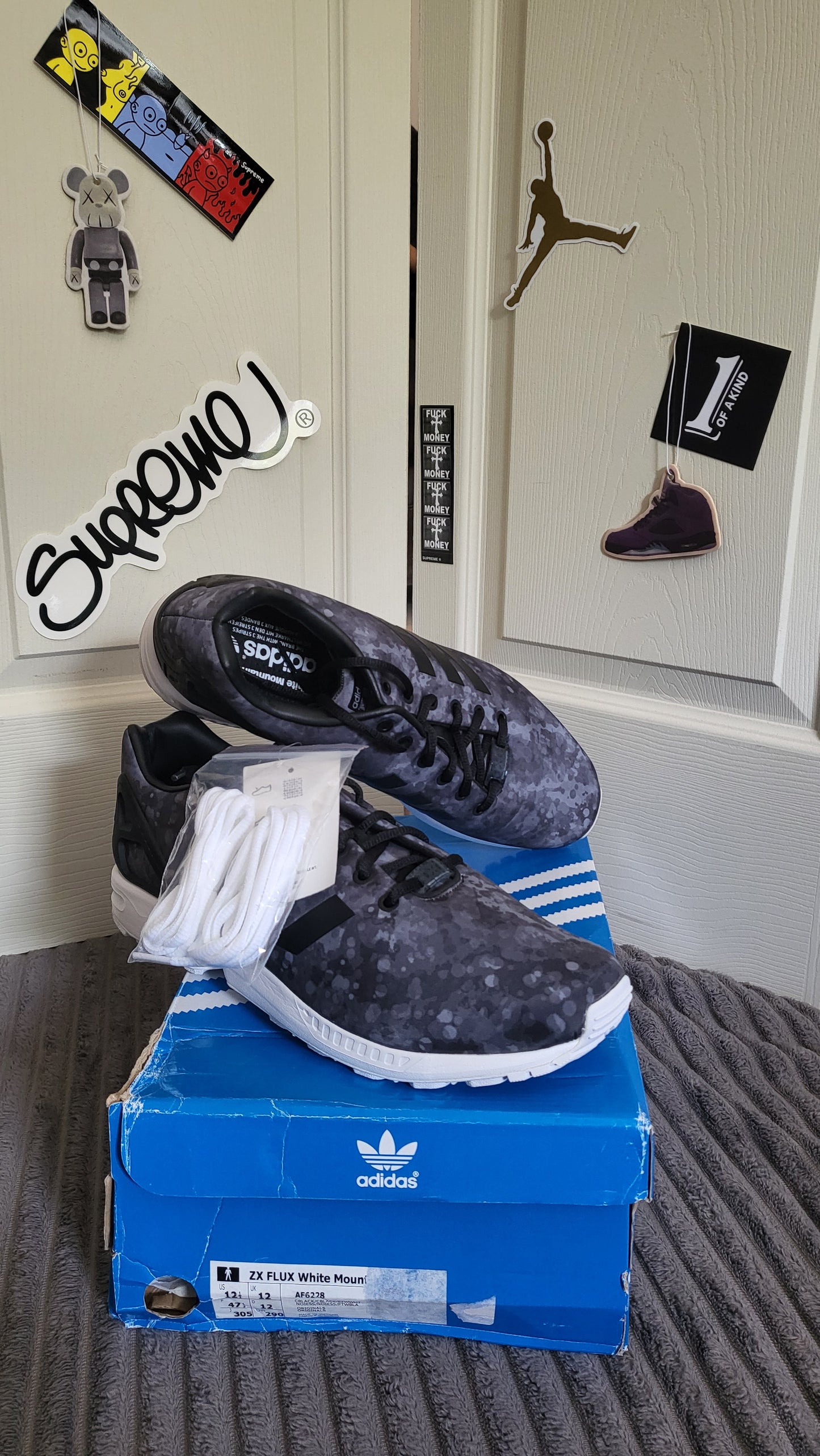 Side and top view of Adidas ZX Flux White Mountaineering with extra laces on box