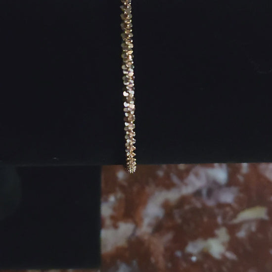 Detailed view of tightly woven spiral rose gold bracelet showing texture and shimmer