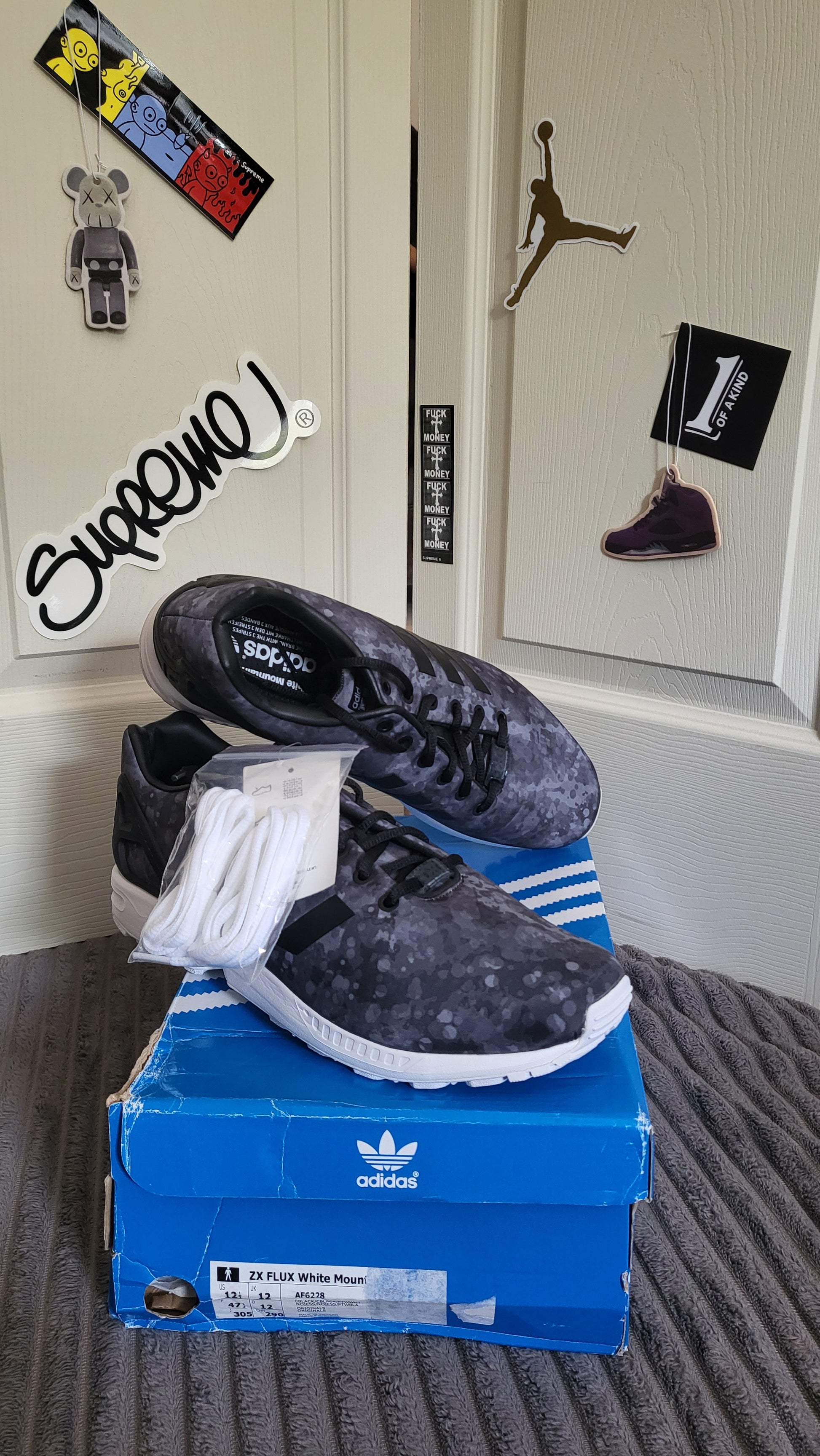 Side and top view of Adidas ZX Flux White Mountaineering with extra laces on box